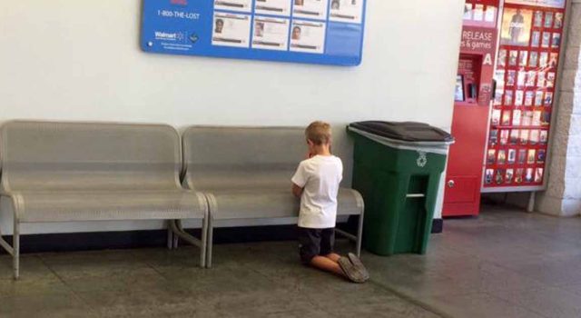 Photo Of Young Boy Praying In Front Of Poster At Walmart Catches The Attention Of Internet Users