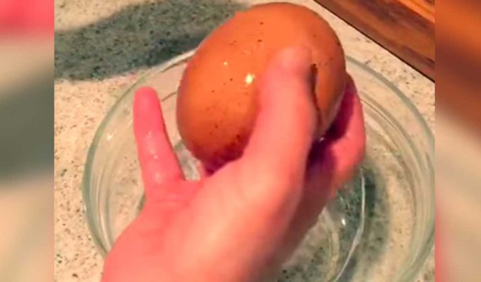 A man cracks open an enormous egg to find something rare inside