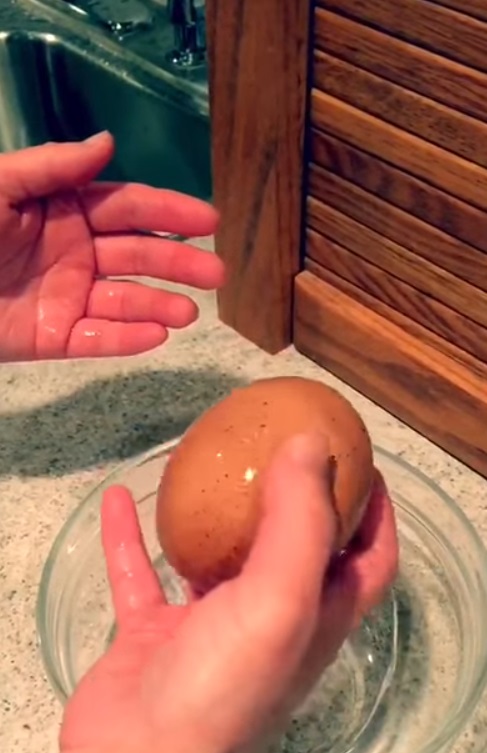 A man cracks open an enormous egg to find something rare inside