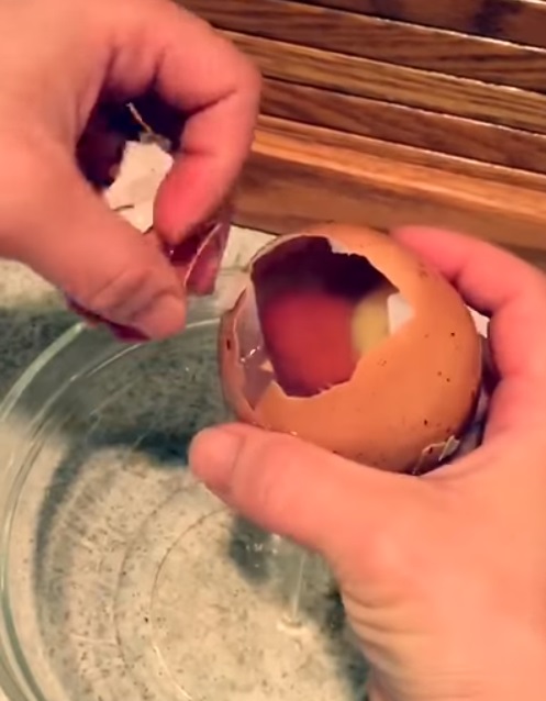A man cracks open an enormous egg to find something rare inside