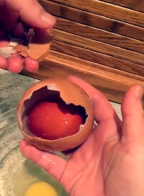 A man cracks open an enormous egg to find something rare inside