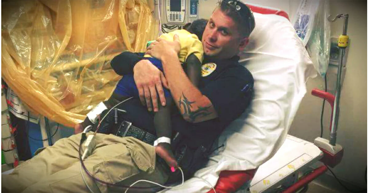 Police officer snuggles abandoned toddler in hospital bed after finding him wandering the streets alone
