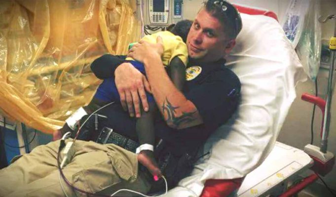 Police officer snuggles abandoned toddler in hospital bed after finding him wandering the streets alone